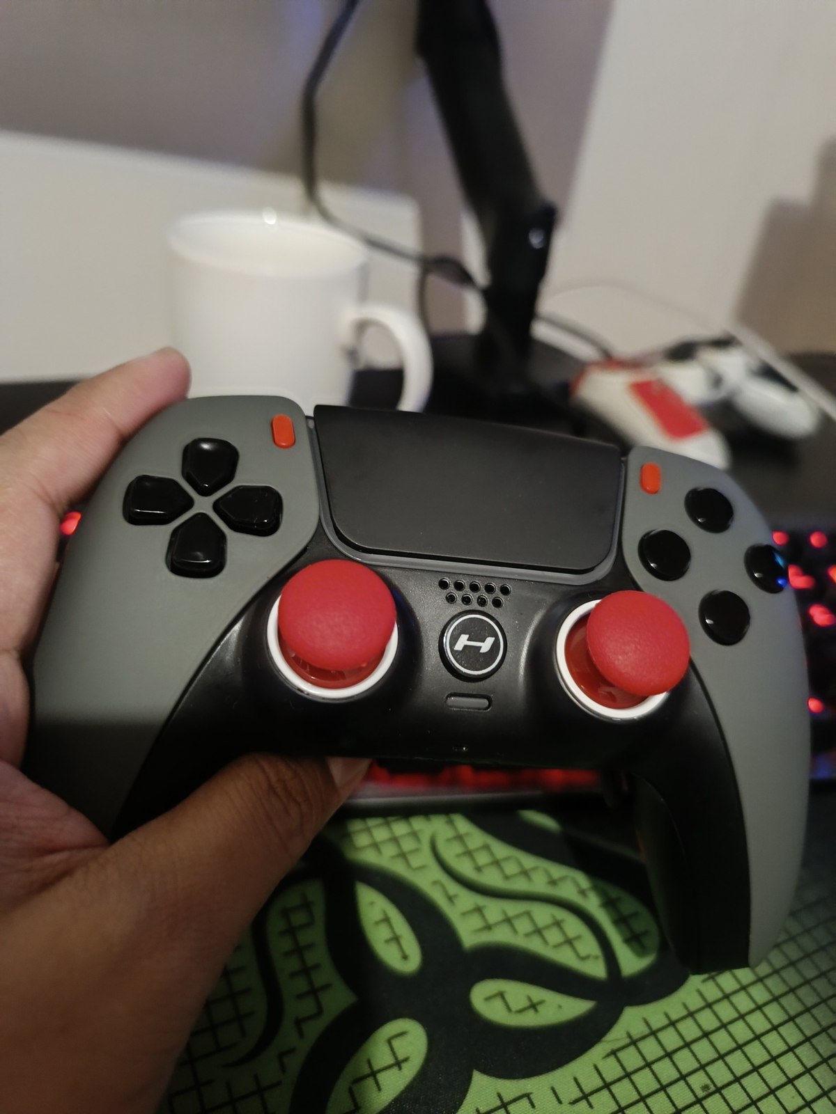 Customer holding a gray HYPR DualSense controller with red thumbsticks