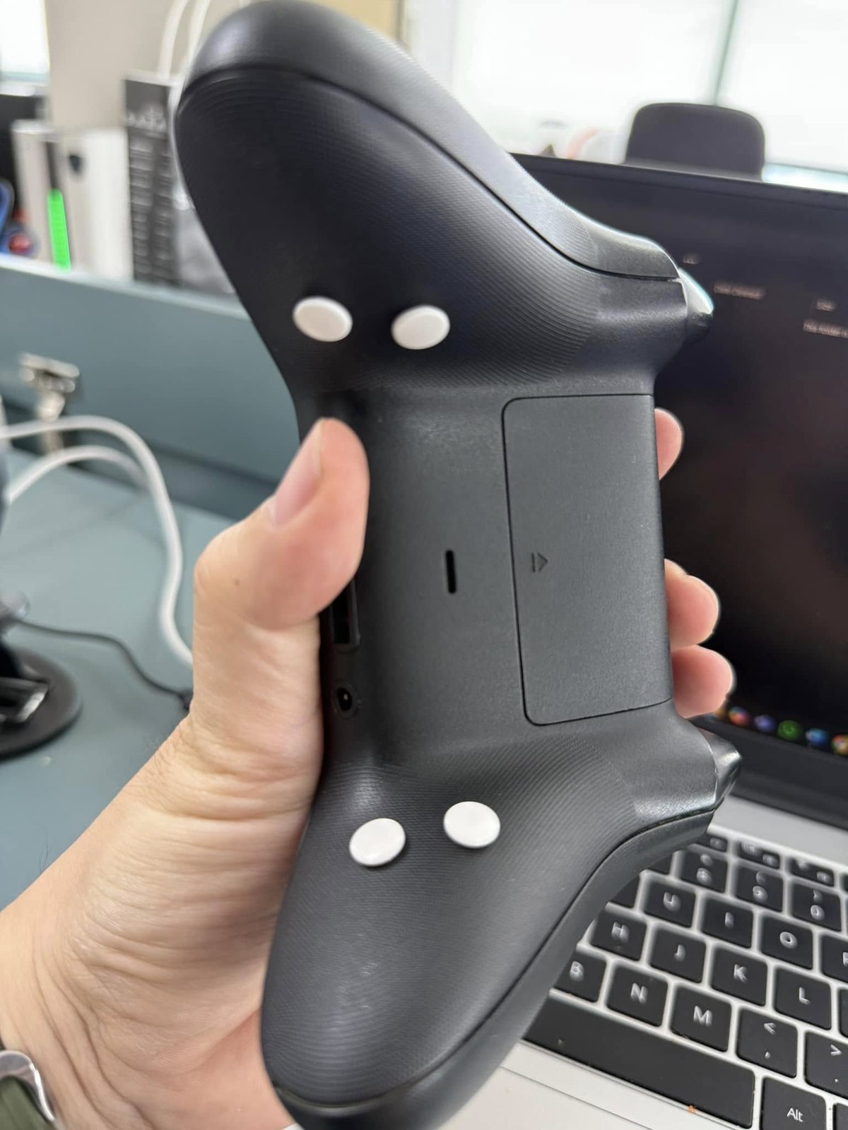 Customer close-up of four white rear buttons on a black controller